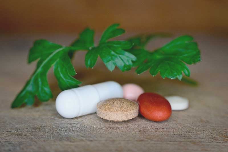 vitamin and mineral pills with parsley sprig